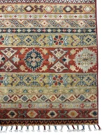 An exquisite Kazak rug featuring vibrant red, blue, and green hues, showcasing artisan craftsmanship and beauty.