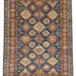 Tappeto Kazak artigianale color marrone, caratterizzato da motivi tradizionali e tessitura dettagliata e artigianale.