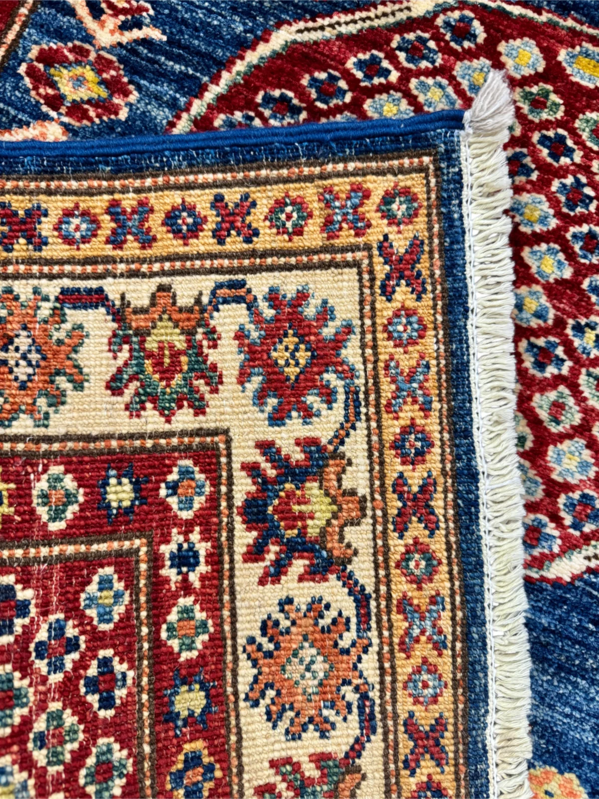 Scopri il tappeto Kazak blu e rosso, realizzato a mano in lana, perfetto per aggiungere stile e eleganza alla tua casa.