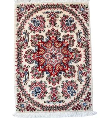 Tappeto Qum Extra qualità persiano 88x62 cm su fondo crema con medaglione rosso e blu, motivi floreali multicolore e frange bianche